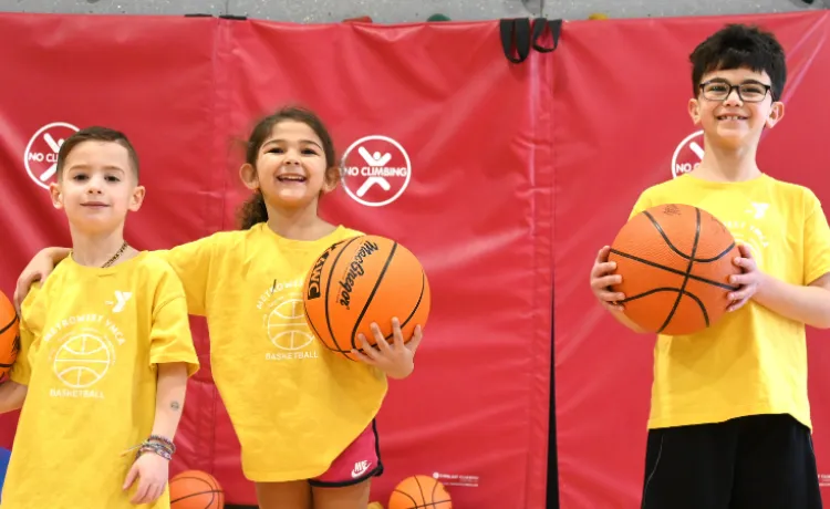 three young kids holding basketballs