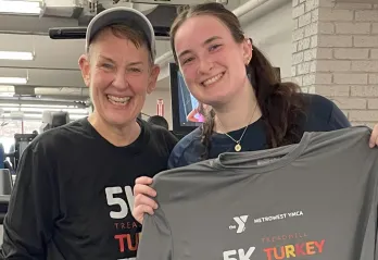 image of mother and daughter standing together in front of treadmills