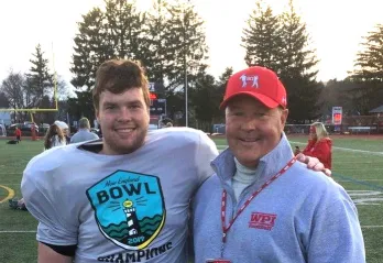 photo of father and son posing at college football game