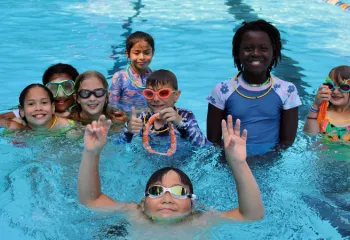 group photo of campers smiling in the pool