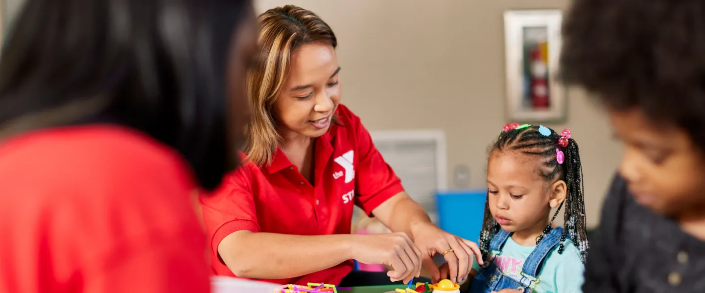 y staff member helping young child