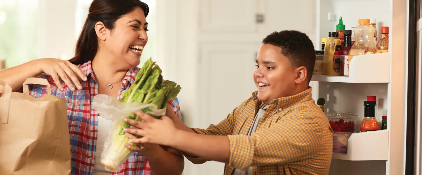 mother and son putting away groceries