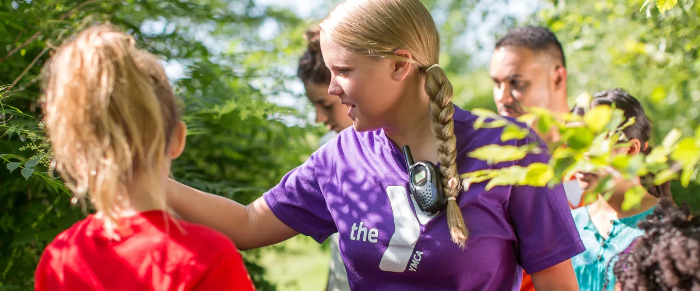 female y staff member showing kids different plants