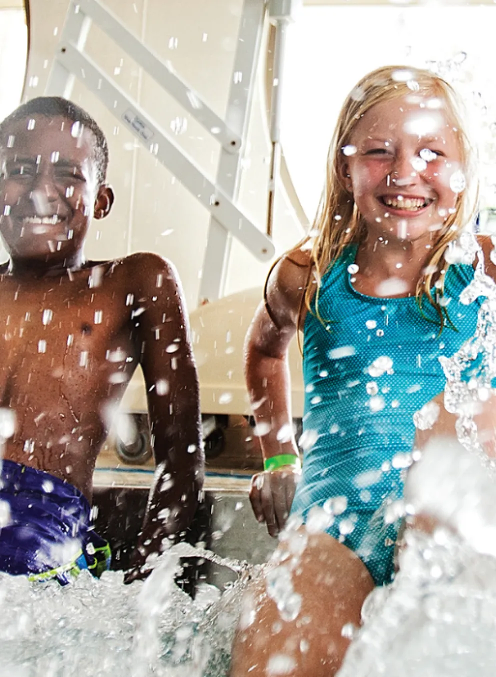 photo of four kids splashing their foot in the pool