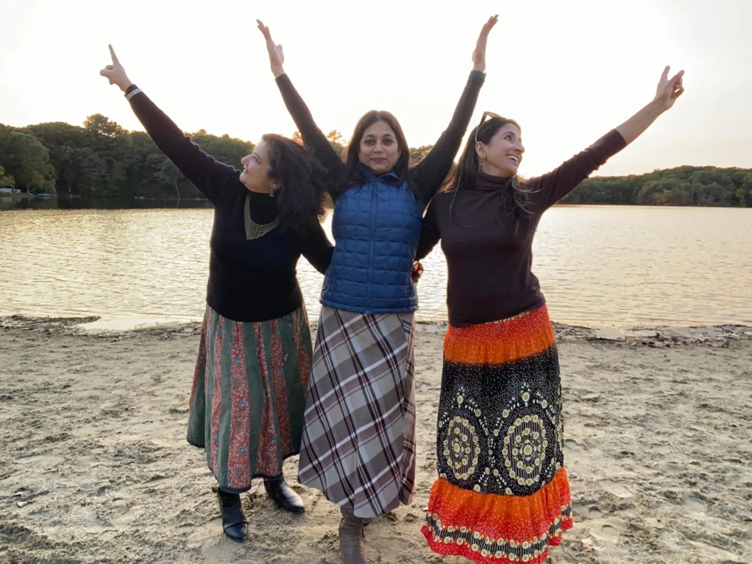 photo of three friends dancing on the beach