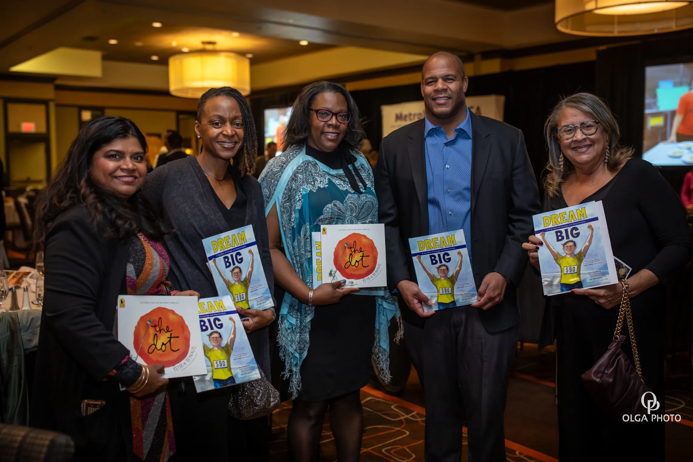 image of a group of people smiling and holding picture books