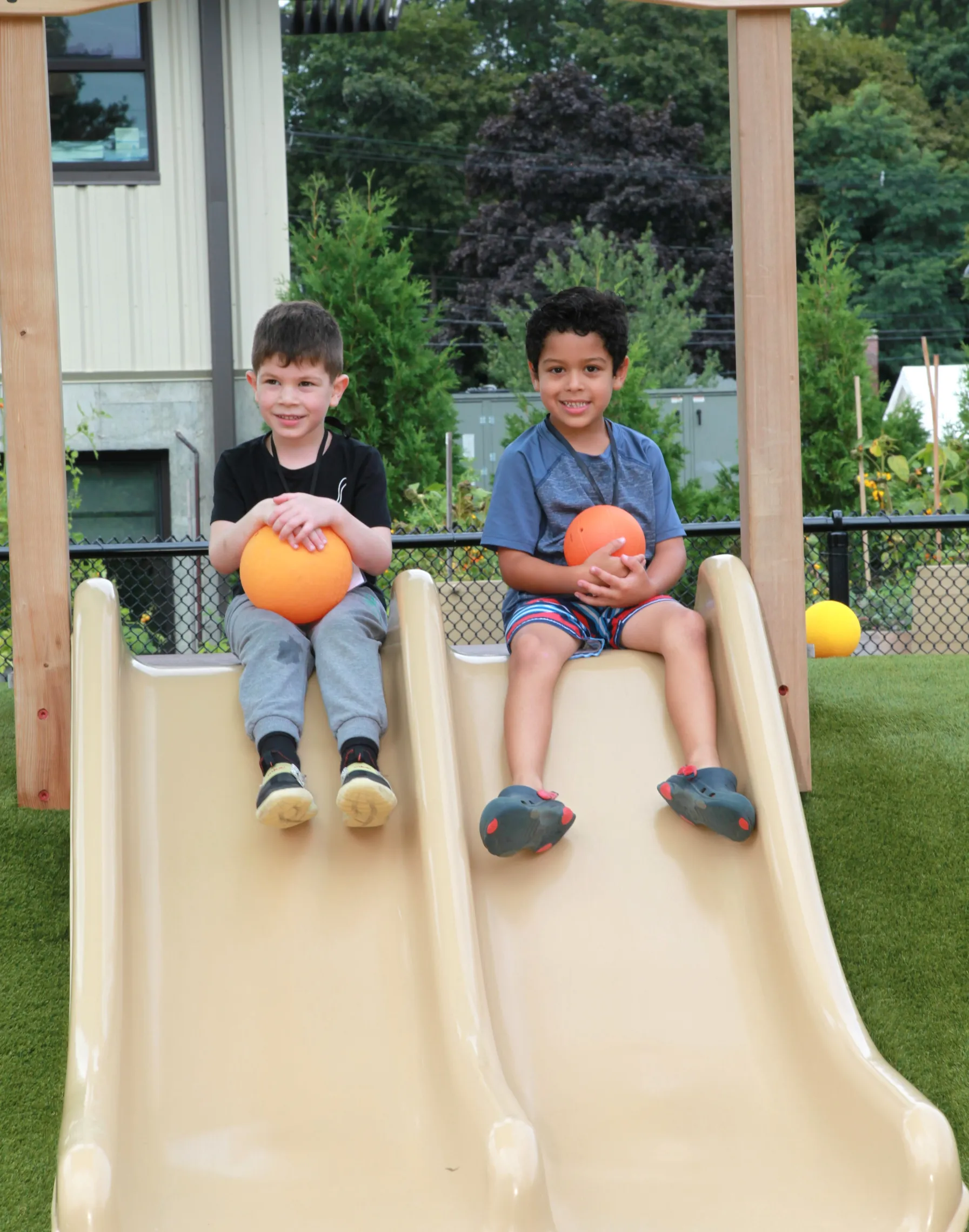 photo of two young boys sitting on slides