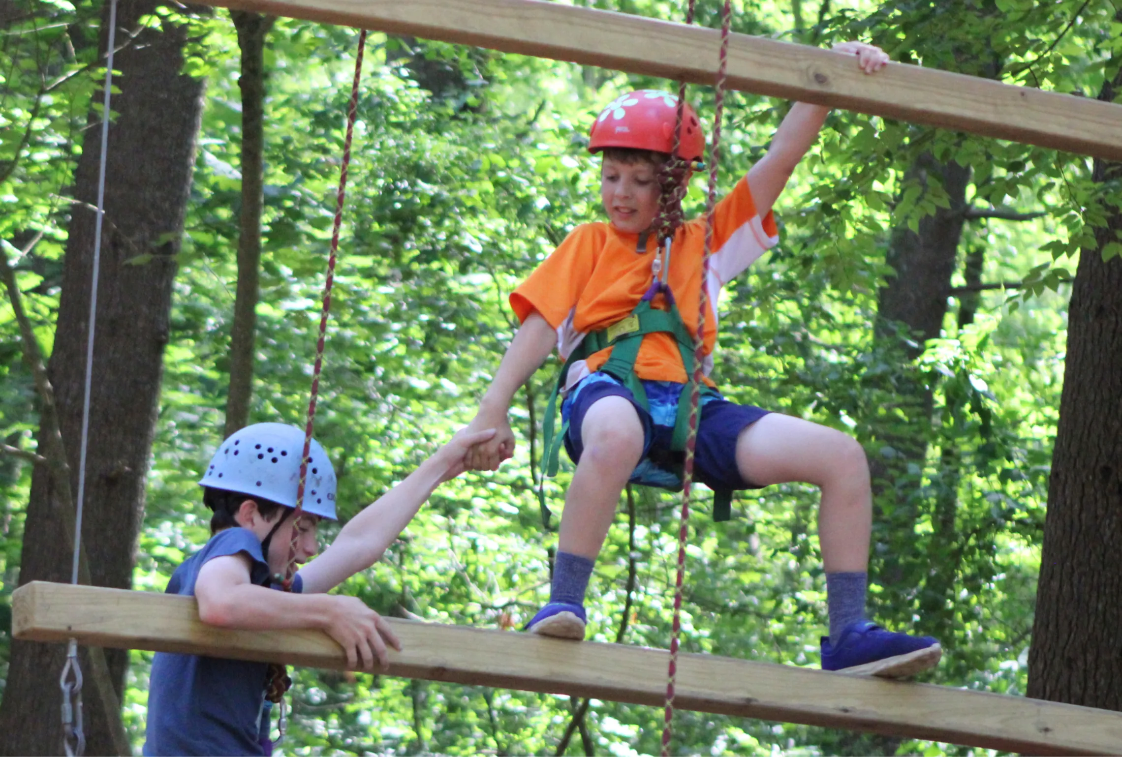 Campers giving a hand up on the ropes course