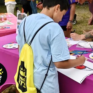 up close photo of boy painting at a table during summer eats kickoff party