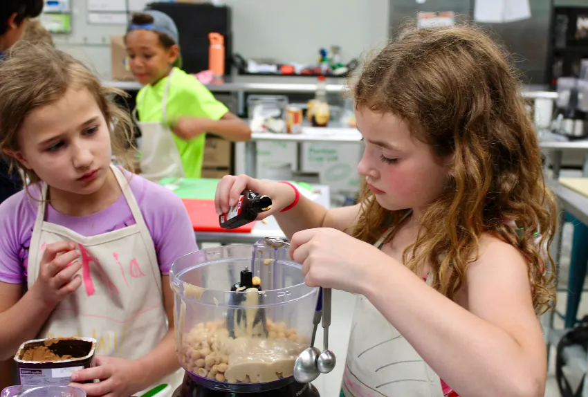 young girls measuring ingredients in cooking class