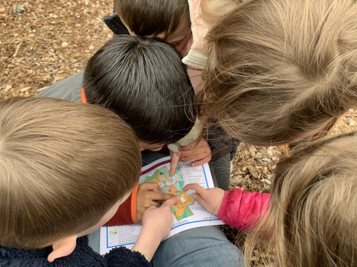 image of kids gathered around a map