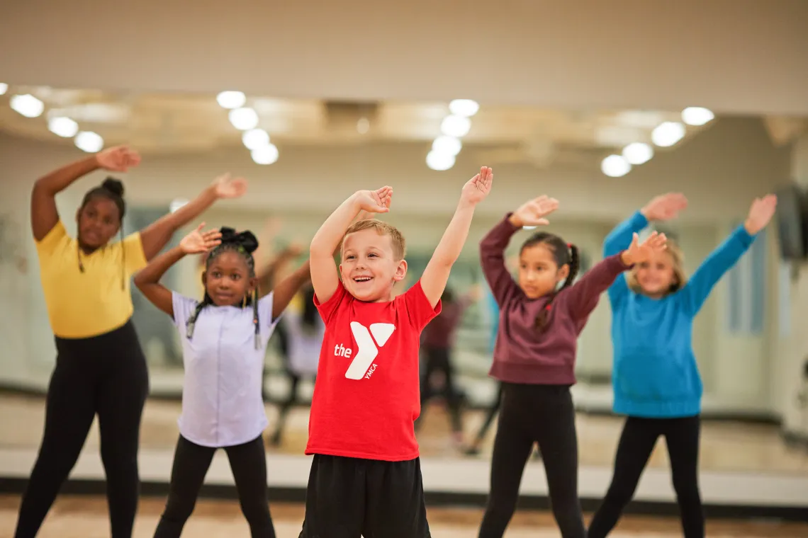 image of group of young kids dancing with their arms in the air