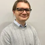 headshot of male adult wearing black glasses